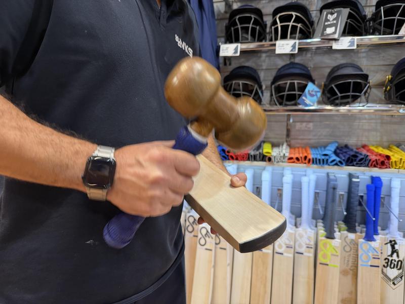 VKS_bat_specialist_knocking_in_the_edge_of_a cricket_bat_by_hand